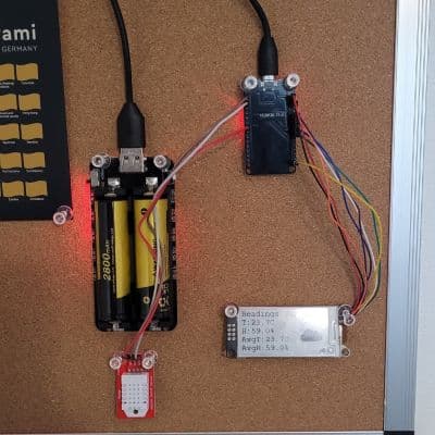 The finished ESP32 climate monitor prototype, mounted on a cork board and battery powered.